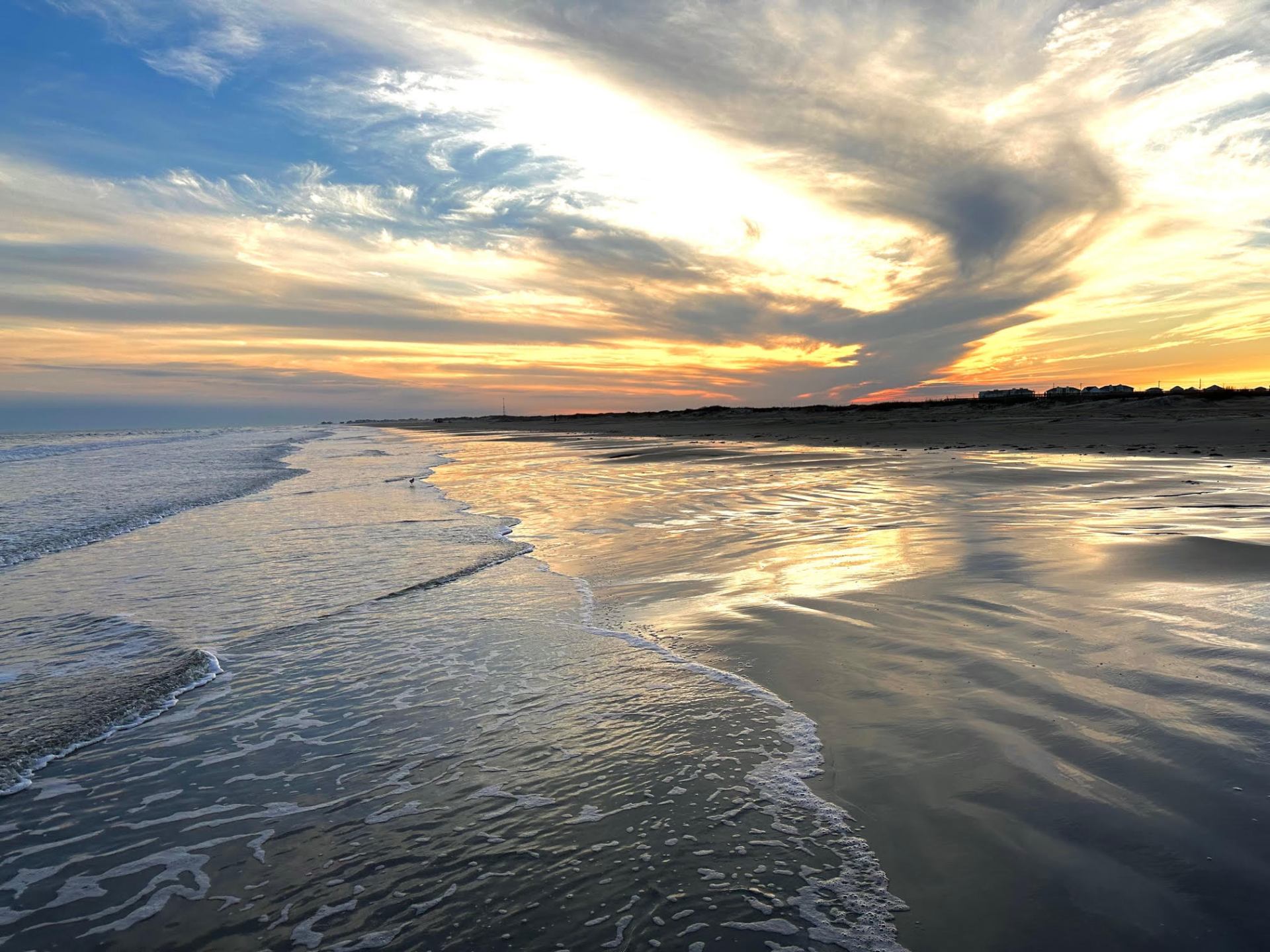 Panoramic Galveston beach sunset with shoreline reflections